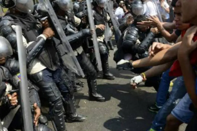 
	Estudantes venezuelanos entram em confronto com a pol&iacute;cia em 12 de mar&ccedil;o de 2014, em Caracas
 (AFP)