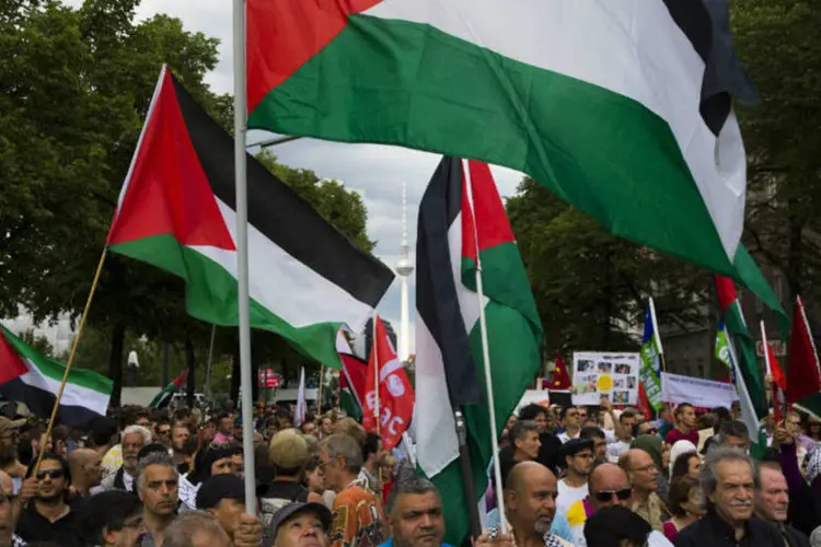 
	Pessoas carregam bandeira da Palestina em protesto contra a a&ccedil;&atilde;o militar de Israel
 (Thomas Peter/Reuters)