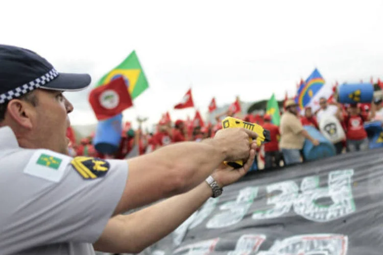 
	PM aponta arma de choque contra integrantes do MST durante protesto: no dia seguinte ao conflito, a presidente Dilma recebeu l&iacute;deres do movimento para debater a pauta de reivindica&ccedil;&otilde;es
 (REUTERS/Ueslei Marcelino)