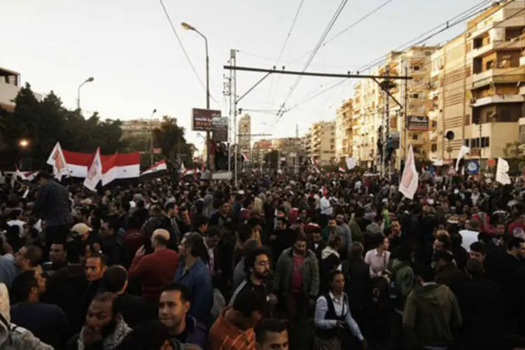 Milhares de egípcios protestam em frente ao palácio presidencial, no Cairo: os opositores também pedem que seja abandonado o referendo sobre o projeto de Constituição (©afp.com / Gianluigi Guercia)