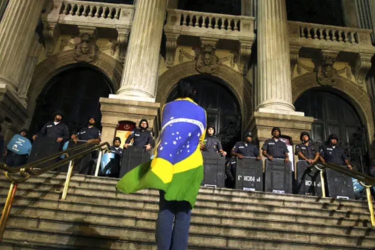 
	Manifestante em frente a policiais durante protesto no Rio de Janeiro
 (Pilar Olivares/Reuters)