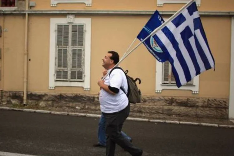 Entre as mobilizações, um homem correu com uma bandeira da Grécia. Cúpula do G20 vai debater o impasse da dívida grega (Christopher Furlong/Getty Images)