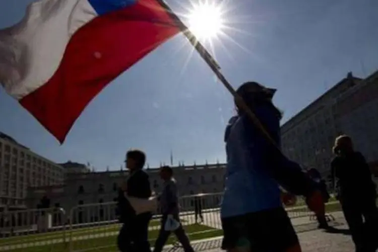
	Estudante carrega bandeira chilena: pa&iacute;s pode ter um crescimento menor
 (Martin Bernetti/AFP)