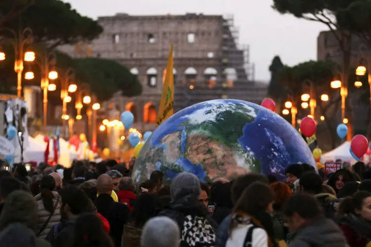 
	Manifestantes carregam um bal&atilde;o do Planeta Terra em Roma, um dia antes da COP 21 em Paris
 (REUTERS/Alessandro Bianchi)