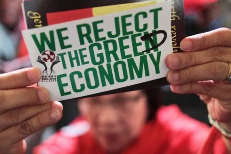 Manifestante usa um cartaz com os dizeres "Nós rejeitamos a economia verde". Com a palavra "verde" trocada por "ganância", em inglês (Ueslei Marcelino/Reuters)