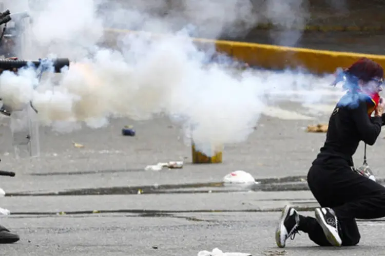 Polícia da Venezuela atira gás lacrimogêneo em manifestantes da oposição durante tumultos em Caracas (Carlos Garcia Rawlins/Reuters)