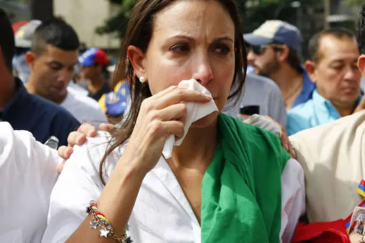 Líder da oposição, Maria Corina Machado, foge do gás lacrimogênio depois dela tentar retomar seu assento na Assembleia Nacional, em Caracas (Jorge Silva/Reuters)
