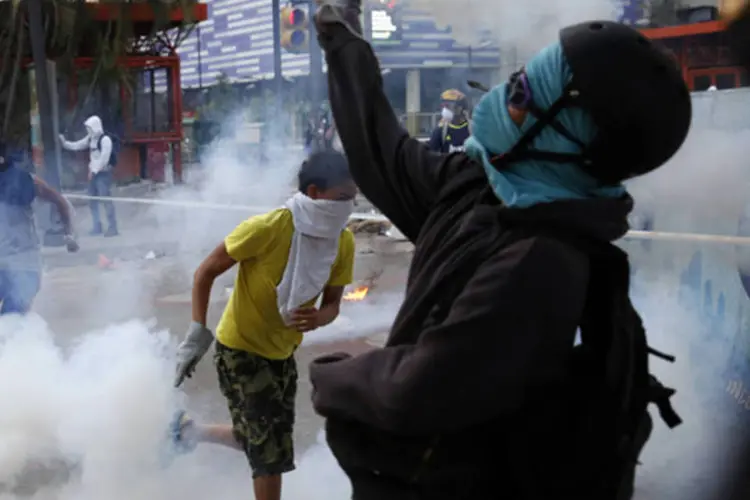 
	Manifestante anti-governo em confronto com for&ccedil;as policiais em Caracas: ontem, o Conselho Permanente da OEA havia feito reuni&atilde;o de pelo menos oito horas
 (Carlos Garcia Rawlins/Reuters)
