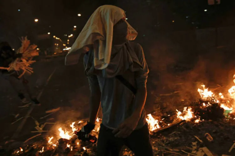 Manifestante da oposição passa por uma barricada na praça Altamira, em Caracas, Venezuela (Carlos Garcia Rawlins/Reuters)