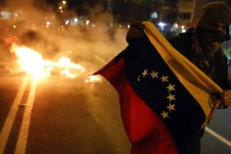 
	Manifestante: protestos deixaram v&aacute;rias dezenas de feridos e muita destrui&ccedil;&atilde;o em &oacute;rg&atilde;os p&uacute;blicos e com&eacute;rcios da zona leste de Caracas (Carlos Garcia Rawlins/Reuters)