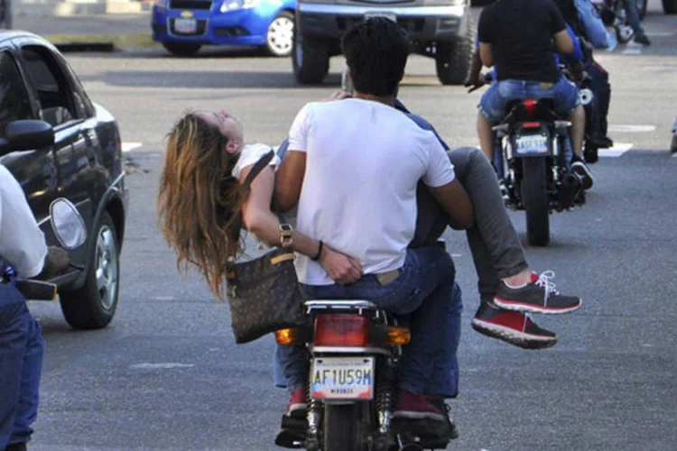 Apoiadora da oposição Genesis Carmona é resgatada em uma moto após ser alvejada na cabeça durante um protesto contra o presidente venezuelano Nicolás Maduro, Valencia (Mauricio Centeno-Notitarde/Reuters)