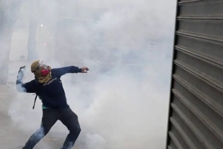 
	Manifestante durante confronto com a pol&iacute;cia em um protesto na Venezuela
 (Carlos Garcia Rawlins/Reuters)