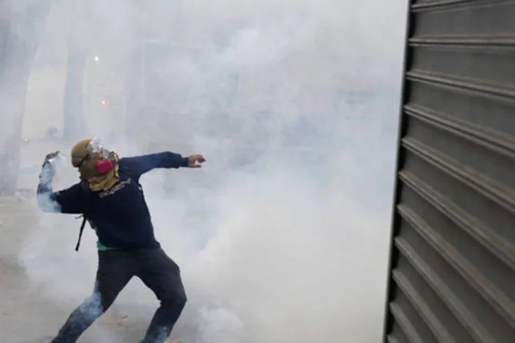 
	Manifestante durante confronto com a pol&iacute;cia em um protesto na Venezuela
 (Carlos Garcia Rawlins/Reuters)