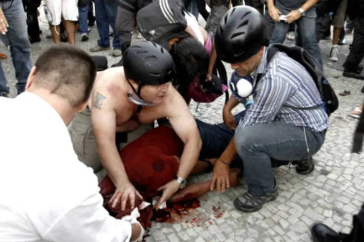 
	Pessoas socorrem o cinegrafista Santiago Andrade, da TV Bandeirantes, depois dele ter sido atingido por um roj&atilde;o em uma manifesta&ccedil;&atilde;o no Rio de Janeiro
 (REUTERS/Andre Mourao/Agencia O Dia)