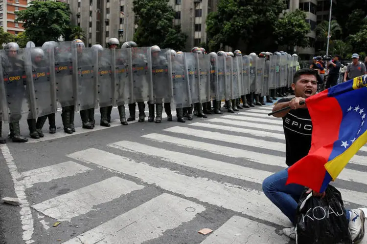 
	Manifestantes contra o governo em confronto com a pol&iacute;cia na Venezuela em maio
 (Carlos Garcia Rawlins / Reuters)