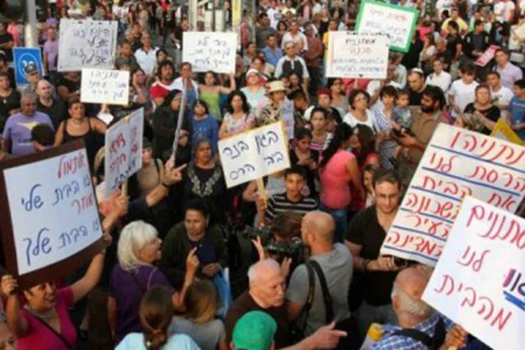 Os manifestantes carregavam cartazes e gritavam frases xenófobas
 (Roni Schutzer/AFP)