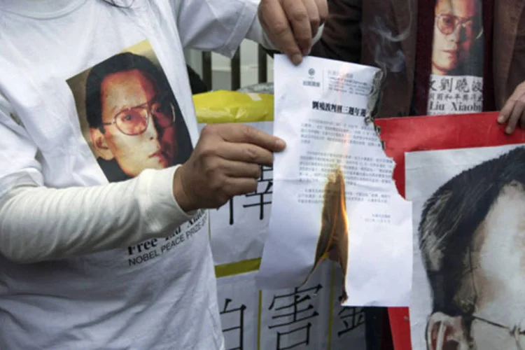 Manifestante pró-democracia queima carta durante um protesto pedindo a liberdade de Liu Xiaobo (Tyrone Siu/Reuters)