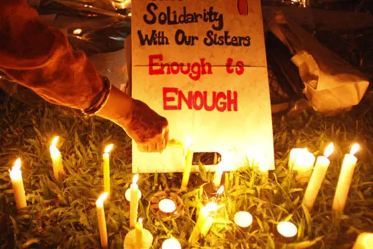 
	Manifestante acende velas pr&oacute;ximas a um cartaz durante protesto em apoio a uma mulher v&iacute;tima de estupro na &Iacute;ndia
 (Edgar Su/Reuters)