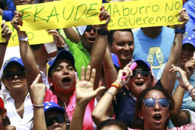 
	Apoiadores do l&iacute;der da oposi&ccedil;&atilde;o venezuelana, Henrique Capriles, protestaram contra elei&ccedil;&atilde;o de Nicol&aacute;s Maduro.
 (REUTERS/Isaac Urrutia)