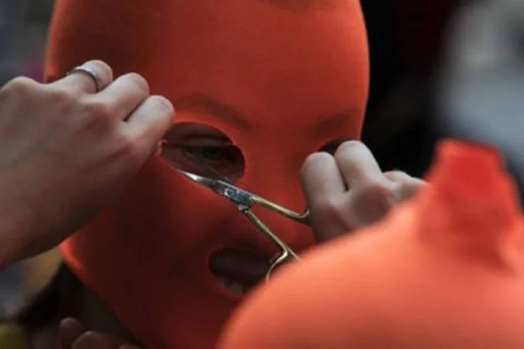 
	Apoiador da Pussy Riot prepara m&aacute;scaras imitando a marca da banda punk durante protesto em Londres: no hospital onde est&aacute; internada Nadia tem um grupo musical
 (Carl Court/AFP)