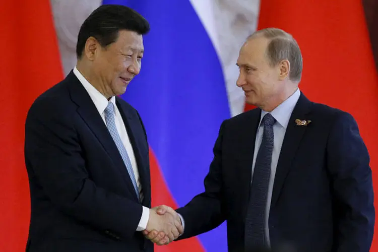O presidente russo Vladimir Putin aperta a mão do presidente chinês Xi Jinping (REUTERS/Sergei Karpukhin)