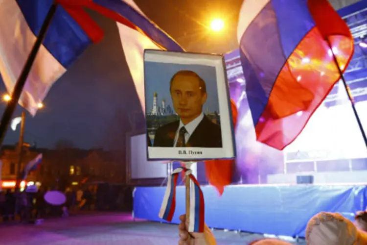 
	Mulher segura retrato do presidente russo Vladimir Putin em celebra&ccedil;&otilde;es na Crimeia: R&uacute;ssia est&aacute; tomando &quot;medidas ofensivas de contra-intelig&ecirc;ncia&quot; para fazer frente aos esfor&ccedil;os ocidentais
 (Shamil Zhumatov/Reuters)