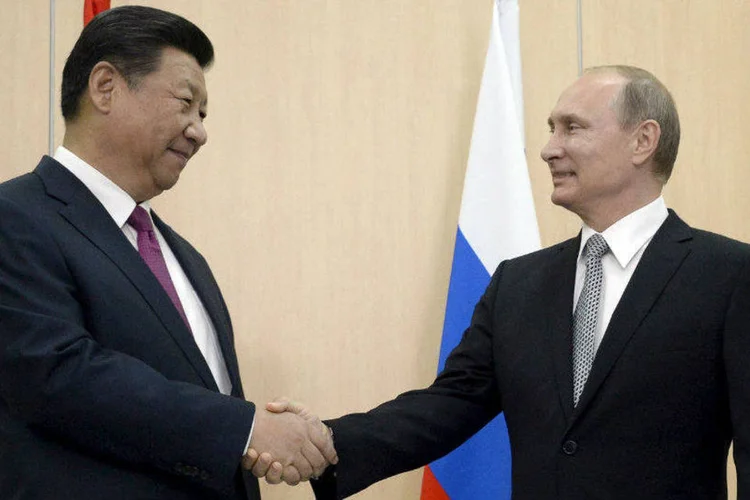 Presidente da Rússia, Vladimir Putin (D), cumprimenta o presidente chinês, Xi Jinping, durante encontro dos Brices na Rússia (Alexander Nemenov/Pool/Reuters)