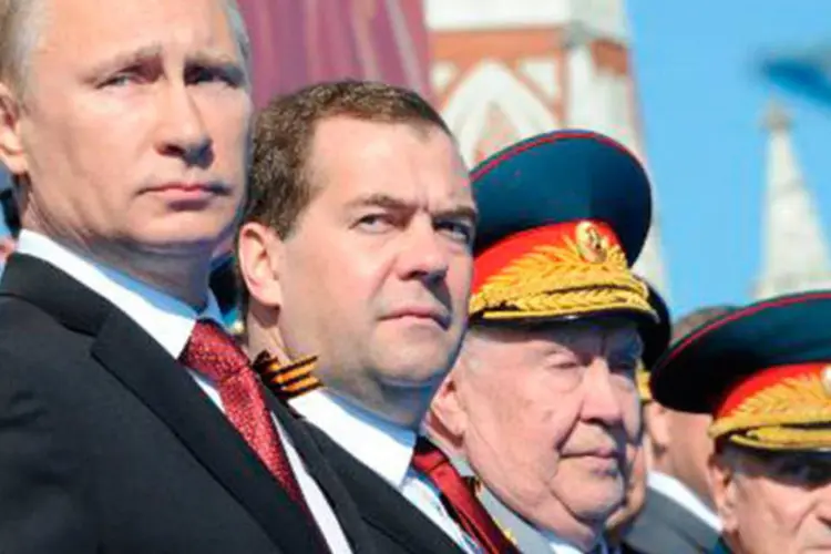 O presidente russo Vladimir Putin (E) e o primeiro-ministro Dmitri Medvedev (2º da esquerda para a direita) durante o desfile militar que recorda a vitória soviética na II Guerra Mundial
 (MIKHAIL KLIMENTYEV/AFP)