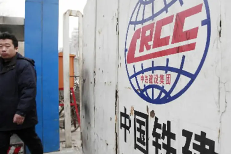 Homem caminha em frente a uma construção da China Railway Construction Corporation (CRCC) em Pequim (Qilai Shen/Bloomberg News)