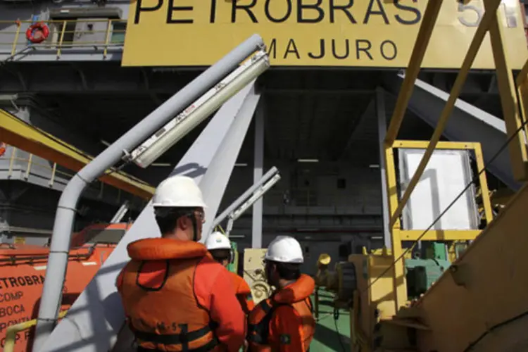 
	Trabalhadores em uma plataforma de petr&oacute;leo da Petrobras: neg&oacute;cio, que j&aacute; havia sido divulgado pela Petrobras, ainda depende de aprova&ccedil;&atilde;o do Cade
 (Rich Press/Bloomberg News)