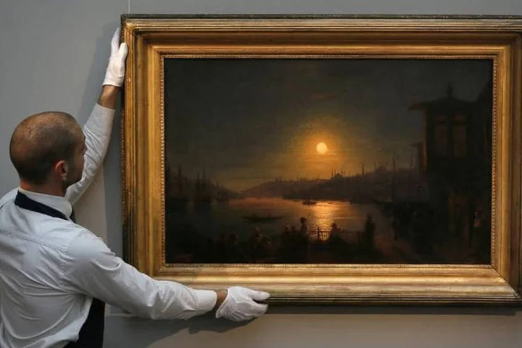 
	Funcion&aacute;rio da Sotheby&#39;s com quadro de Ivan Aivazovsky &quot;Evening in Cairo&quot; em Londres
 (REUTERS/Stefan Wermuth)