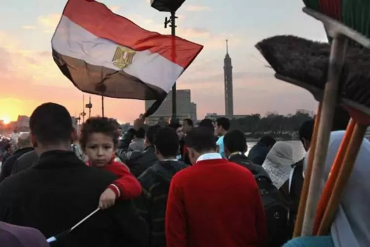 Egípcios atravessam a praça Tahrir após a queda de Mubarak: Síria tinha se mantido até agora à margem das revoltas populares que triunfaram na Tunísia e Egito, e que se estenderam à Líbia (John Moore/Getty Images)
