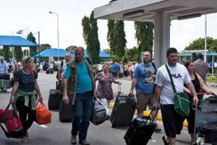 
	Turistas chegam ao aeroporto de Mombasa para a viagem de volta: ag&ecirc;ncias de viagens come&ccedil;aram a repatriar 400 turistas que estavam no litoral e cancelaram voos para Mombasa

	
	
 (AFP)