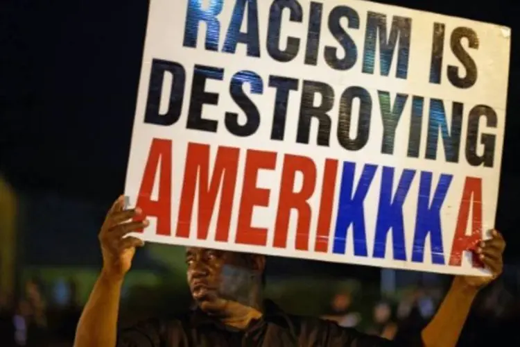 Manifestante leva cartaz contra racismo em protesto em Ferguson, no Missouri (Michael B. Thomas/AFP)