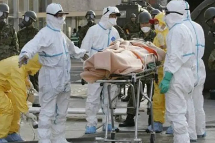 Suposta vítima de contaminação radioativa é levada para centro de tratamento no Japão (Jiji Press/AFP)