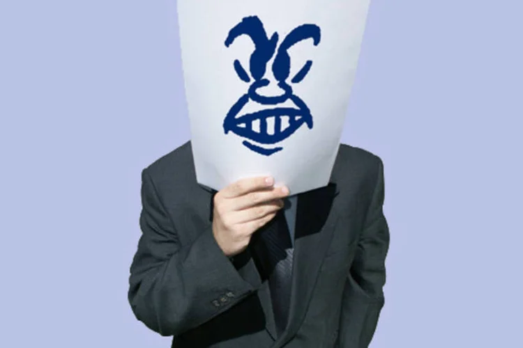 Executivo segurando um papel com o emoticon da raiva (Stock.XCHNG)