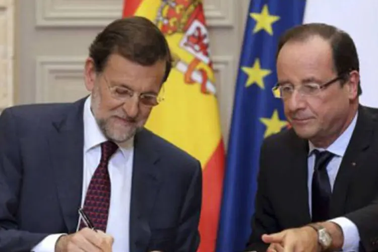 François Hollande (D) e Mariano Rajoy assinam acordo: ainda segundo o líder espanhol, "não há nenhuma razão para que o que se decidiu em junho não seja feito em dezembro" (©AFP / Philippe Wojazer)