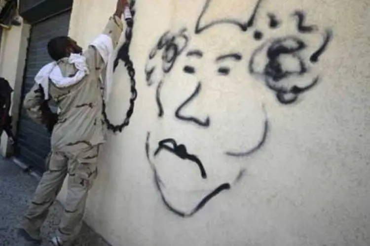 Um rebelde faz uma charge do coronel Kadafi: o fim da missão da Otan não depende da captura do ditador, mas sim da "avaliação da situação de segurança" (Filippo Monteforte/AFP)
