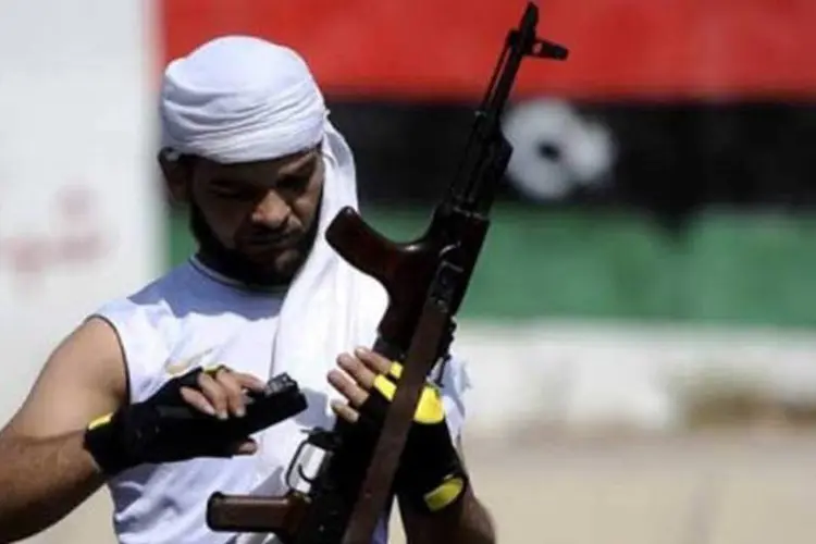 Rebelde carrega cartucho de metralhadora na Líbia (AFP)