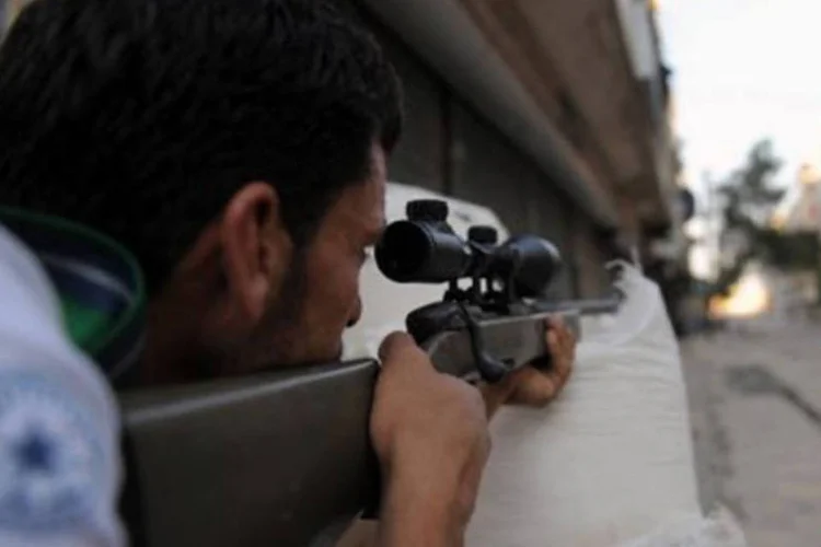 Rebelde da oposição síria observa movimento em rua de Aleppo: a oposição (a Kadhafi) havia pedido a intervenção internacional. Havia um consenso internacional (Bulent Kilic/AFP)