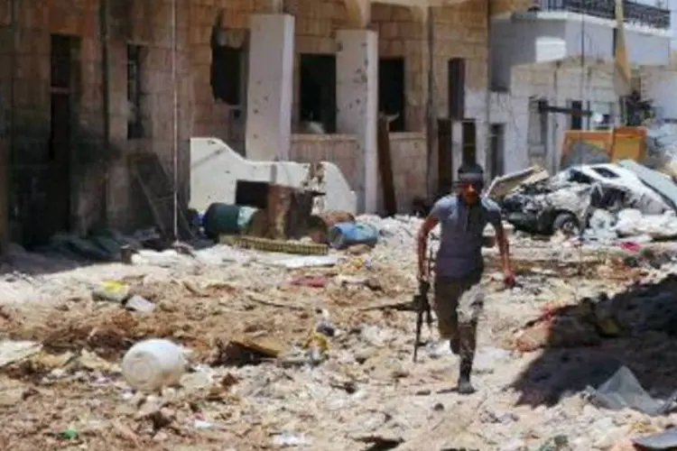 Rebelde corre em uma rua de Daraa, na Síria: mais de 140 mil pessoas morreram na Síria desde o início do conflito, em março de 2011 (AFP)