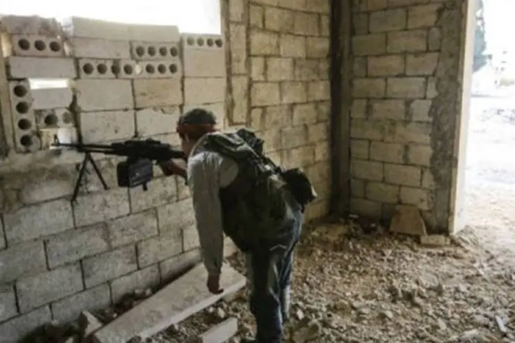 Rebelde observa ações do exército sírio em Maarat al-Numan
 (John Cantlie/AFP)