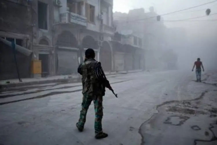 Rebelde moderado em meio à fumaça após suposto ataque aéreo do Exército sírio (Ahmed Deeb/AFP)