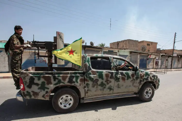 
	Rebeldes curdos na zona de Tel Abiad: este tipo de bombardeios desde a fronteira contra posi&ccedil;&otilde;es do YPG ocorre desde s&aacute;bado passado
 (Getty Images / Ahmet Sik)
