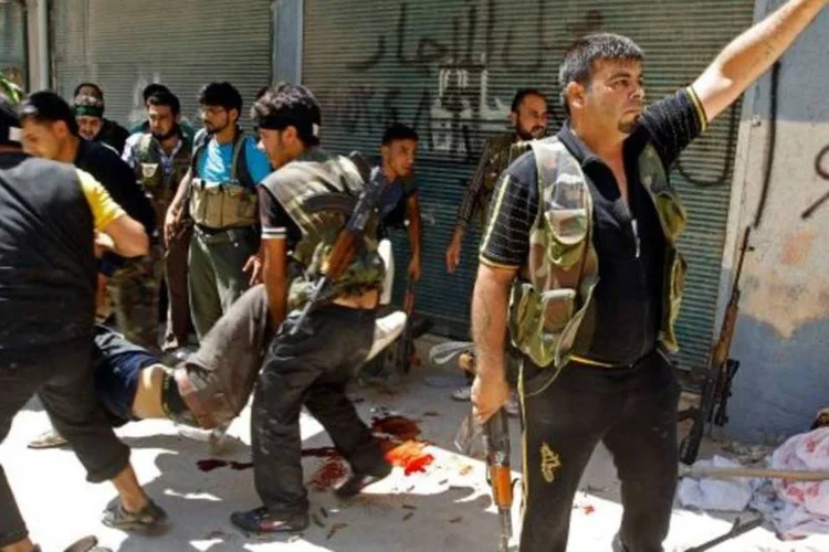 
	Rebeldes do Ex&eacute;rcito Livre da S&iacute;ria carregando feridos em Alepo, ap&oacute;s conflitos
 (Goran Tomasevic/Reuters)
