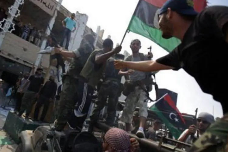 Rebeldes líbios tomam o complexo de Bab al-Aziziya em Trípoli, antiga residência de Kadafi: eles oferecem US$ 1,7 milhão pelo ditador, vivo ou morto (Patrick Baz/AFP)