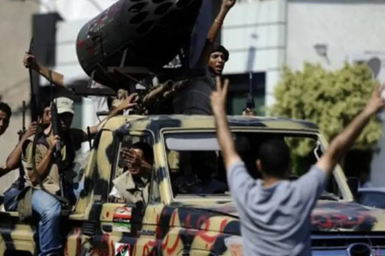Rebeldes, que iniciam ataque contra a residência de Kadhafi, em rua de Trípoli
 (Filippo Monteforte/AFP)