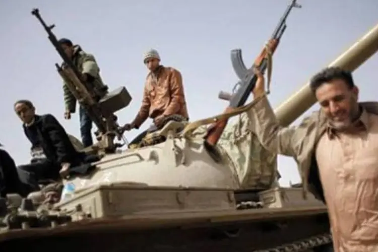 Rebeldes comemoram a tomada da cidade de Brega, na Líbia: agora oposição está na internet (Marco Longari/AFP)