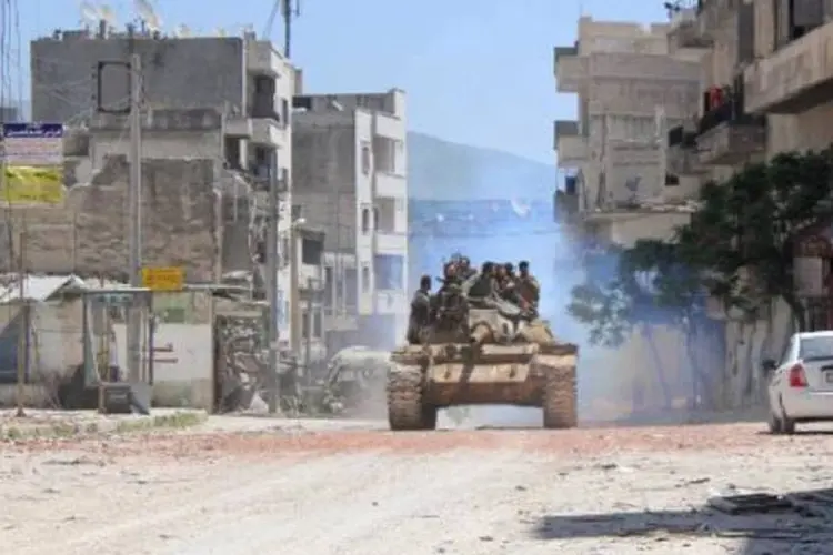 
	Rebeldes se deslocam em um tanque, em cidade s&iacute;ria: &quot;Mas continuo com medo das bombas e tamb&eacute;m temo o retorno do EI&quot;, diz refugiada
 (Ali Nasser/AFP)