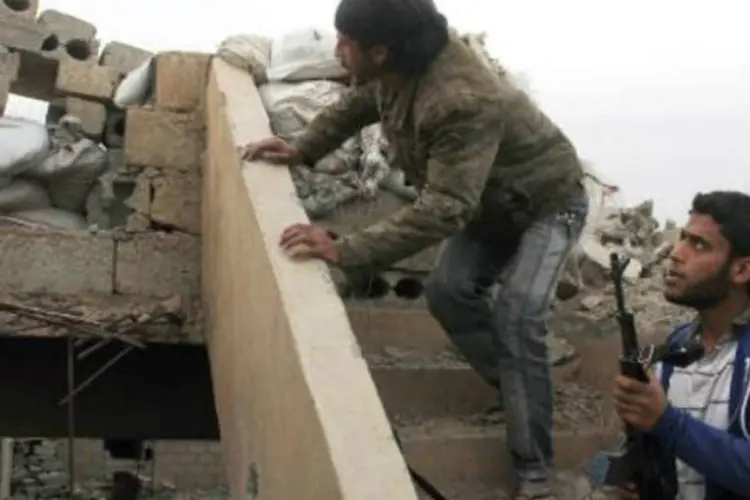 
	Rebeldes em barricada constru&iacute;da no telhado de um pr&eacute;dio na cidade s&iacute;ria de Deir Ezzor
 (Ahmad Aboud/AFP)